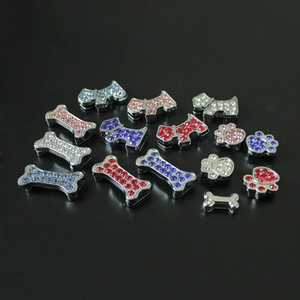 Close-up of sparkling rhinestone paw and bone charms for DIY bracelets and pet collars
