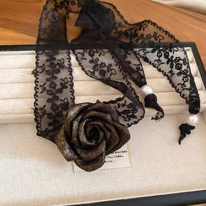 Detail showing the 3D rose flower and pearl drop on this elegant black lace choker