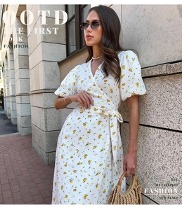 Détail d'une robe portefeuille fleurie avec manches bouffantes et fleurs jaunes sur coton