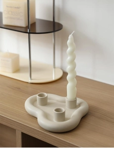 Détail d'un bougeoir nordique en céramique à 3 trous avec bougie spirale blanche