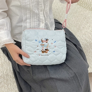 Detail of light blue quilted pouch with dachshund embroidery and pink wrist strap