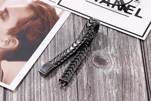 Makroaufnahme von dunkelgrauem Titanstahl-Armband mit mechanischer Schuppentextur und Mattierung