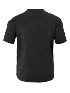 Macro detail of black short sleeve polo shirt featuring unique 3D jacquard textured fabric