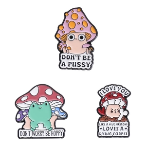 Cartoon mushroom and frog enamel pins set with humorous text on white background