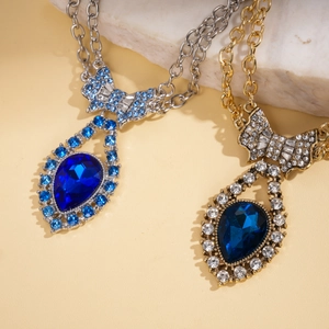 Detail of luxury teardrop necklaces with rhinestone bowknot and blue gemstone pendants