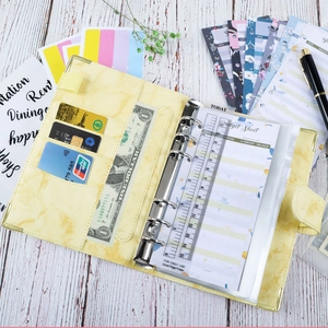 Detail of yellow marble A6 PU leather binder with gold metal corners and budget accessories