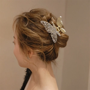 Detail of large butterfly hair claw with rhinestones styled in a French twist updo