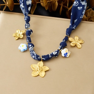 Collier avec pendentifs de fleurs dorées et ruban en tissu bleu foncé avec imprimé vintage