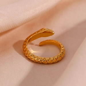 Vintage gold plated stainless steel snake ring with white diamond eyes on pink silk fabric