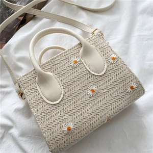 Beige woven straw crossbody bag with daisy embroidery and elegant leather handle