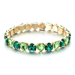Chic gold heart-shaped bracelet with green zircon crystals on a white background