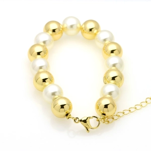 Detailed shot of gold plated copper beads and white pearls on adjustable lobster clasp bracelet
