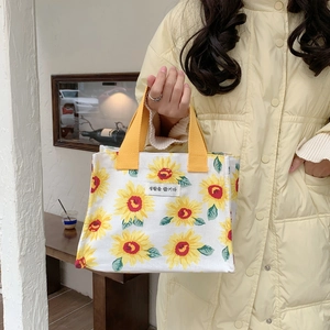 Detail of sunflower print canvas lunch bag with durable yellow woven handles
