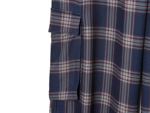 Close-up of side cargo pocket on dark blue plaid trousers with detailed stitching