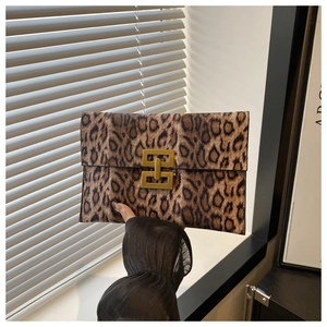 Detail of leopard print envelope clutch featuring a gold rectangular interlocking clasp