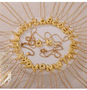 Detailed overhead view of 26 3D balloon letter pendants in polished gold-plated copper