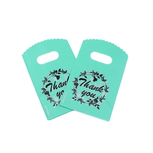 Detail of mint green plastic gift bags with Thank You floral print and handle cutouts