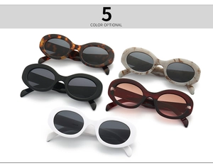 Flat lay of oval retro sunglasses in five colors including marble and tortoiseshell patterns