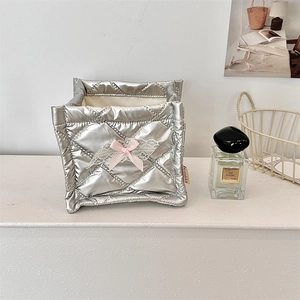 Close-up of silver quilted storage box featuring a pink bow and elegant lace trim