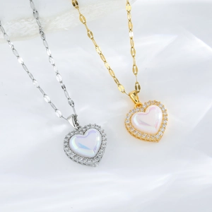 Golden and silver heart necklaces with iridescent opal pendants on white fabric