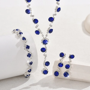 Elegant silver necklace bracelet and earrings set with deep blue gems and crystals