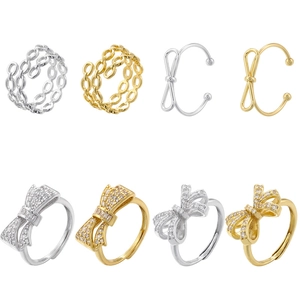 Close-up of luxury bow and chain rings set with zircon accents on white background