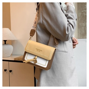 Detail of color-block flap crossbody bag with vintage embroidered wide strap and tassel