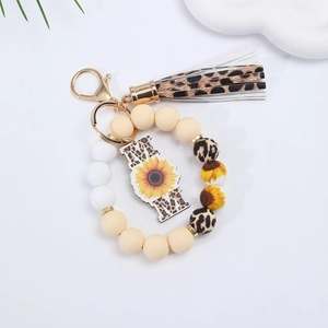 Detail of silicone beaded wristlet keychain with leopard tassel and MOM sunflower pendant