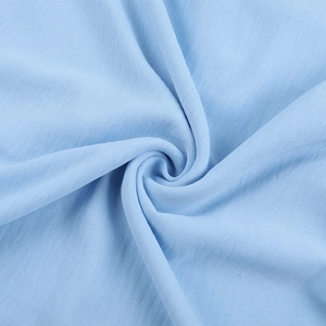 Vue détaillée du tissu scintillant bleu clair avec plis doux et texture fine