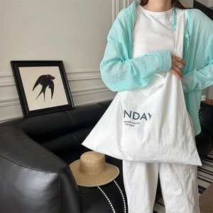 Detailed view of white canvas tote bag with NDAY SUMMER NIGHT print for summer style