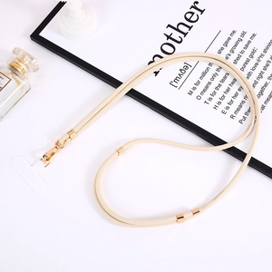 Dettaglio del cordino beige in nylon intrecciato con fibbia in metallo dorato e toppa