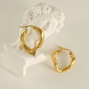Modern 18k gold plated irregular hoop earrings on artistic white plaster sculpture