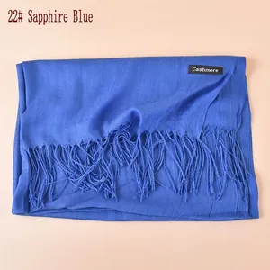 Detail of royal blue cashmere-like scarf showing soft texture and tassel fringe edges