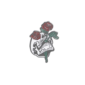 Halloween skull brooch with red roses and green leaves on a polished metal finish