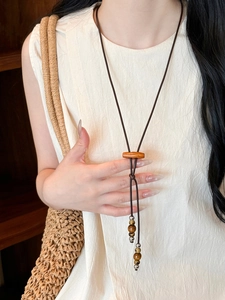 Detail of bohemian coconut wood bead necklace featuring rustic textures on clothing