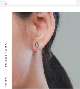 Close-up of model wearing a sparkling marquise-cut diamond silver stud earring