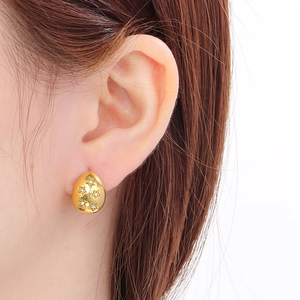 Macro view of 18K gold-plated star drop earrings with cubic zirconia on model's ear