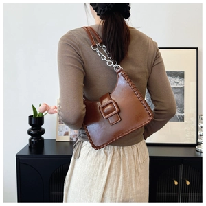Detail view of brown PU leather shoulder bag with hand-stitched edges and silver chain strap