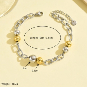 Detail of mixed-metal steel bracelet showing bicolor beads and links on a neutral background