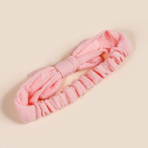 Detail of pink cotton baby headband showing texture and elastic back with big bow