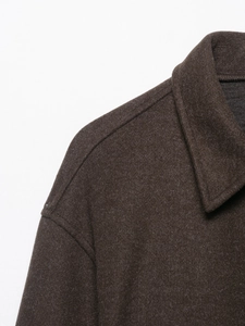 Gros plan du revers et des coutures d'épaule d'une veste en laine marron foncé