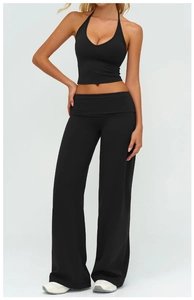 Detail of black V-neck halter yoga vest and wide-leg trousers on a studio model
