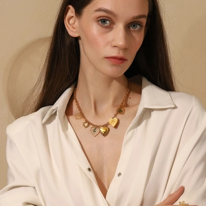 Collana a catena in acciaio placcato oro 18K con ciondoli a cuore e quadrifoglio su modella