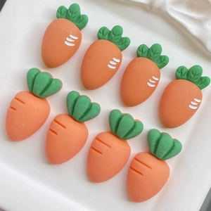 Detail of eight resin carrot charms for DIY crafts and hair clips on a white plate