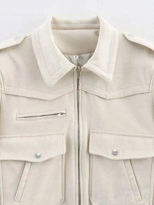 Gros plan détaillé de la veste baseball crème avec fermetures éclair métalliques