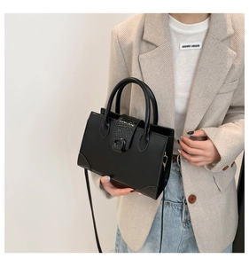 Dettaglio di una borsa chic in pelle PU nera con fibbia in metallo e tracolla regolabile