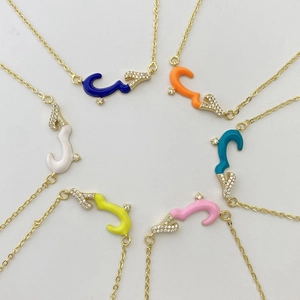Close-up of colorful Arabic calligraphy pendants with enamel and sparkling crystals