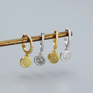 Detail of gold and silver sterling silver hoop earrings with zircon smiley face charms