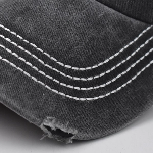 Macro shot of distressed brim on washed cotton baseball cap with white contrast stitching