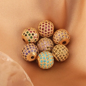 Macro detail of colorful cubic zirconia pave beads with gold-plated base for DIY jewelry